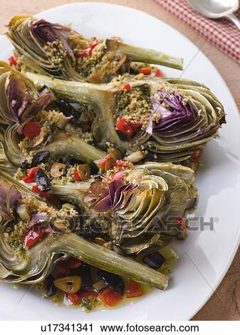 Stock Image - Roasted Globe Artichokes with Aubergine Peppers and Olives. Fotosearch