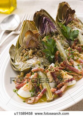 Stock Photo - Roasted Globe Artichokes with Pancetta Egg and Garlic Breadcrumbs. Fotosearch