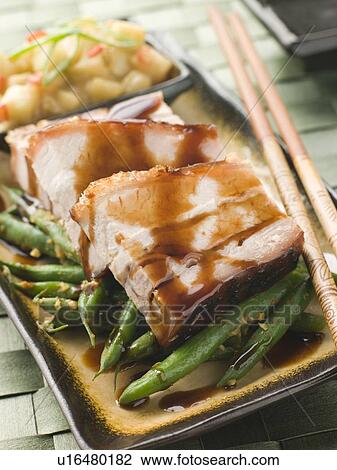 Stock Image - Roast Belly Pork with Fuji Apples and Peanut Beans. Fotosearch