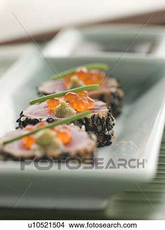 Picture - Seared Yellow Fin Tuna Rolled in Sesame seeds with Wasabi and Salmon Roe. Fotosearch