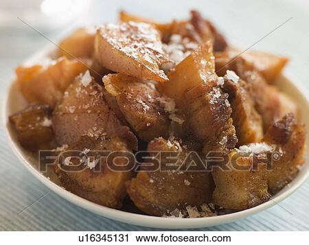 Stock Image - Dish of Chicharrones with Sea Salt Flakes. Fotosearch