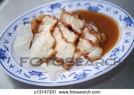 Stock Image - Close-up of braised pork on the plate. Fotosearch