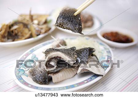 Stock Image - Close-up of milkfish skin on the plate. Fotosearch