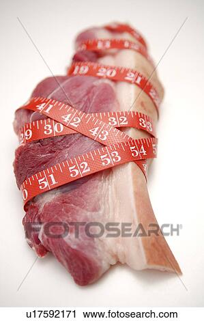 Stock Image - Close-up of pork twisted by tape measure. Fotosearch