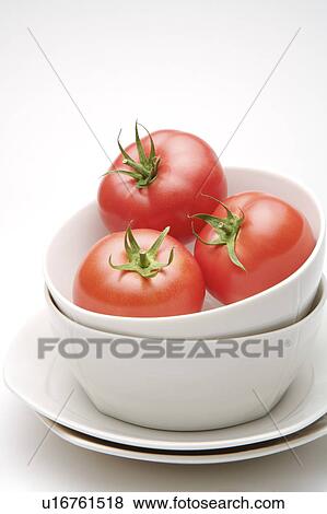 Stock Photo - Close-up of three tomatoes in a bowl. Fotosearch