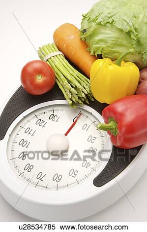 Stock Photography - Different kinds of vegetables on the weight scale. Fotosearch