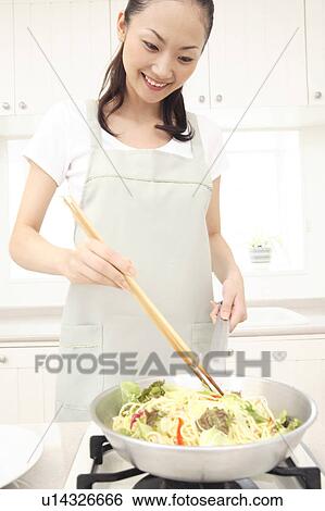 Stock Photograph - Japanese woman cooking. Fotosearch
