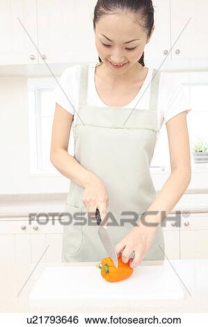 Stock Photograph - Japanese woman cutting paprika. Fotosearch