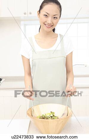 Stock Image - Japanese woman making a salad. Fotosearch