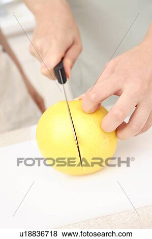 Stock Photo - Woman cutting a fruit. Fotosearch
