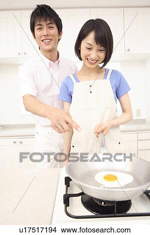 Picture - Woman making a fried egg with her husband. Fotosearch