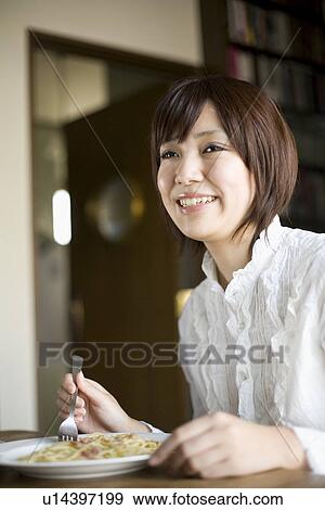 Stock Photo - Young woman eating spaghetti. Fotosearch