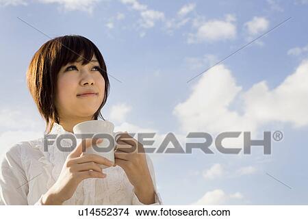 Young woman holding cup View Large Photo Image Picture - Young woman holding cup. Fotosearch