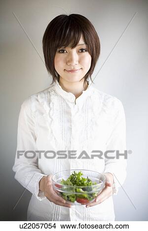 Young woman holding salad bowl View Large Photo Image Picture - Young woman holding salad bowl. Fotosearch
