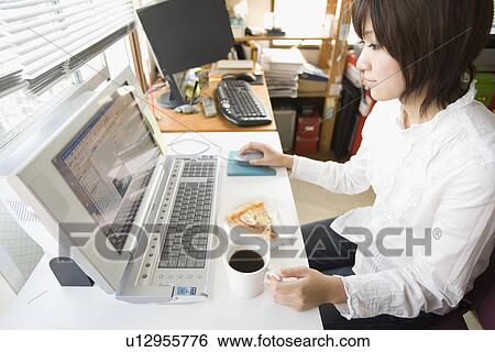 Stock Photograph - Young woman looking PC monitor. Fotosearch