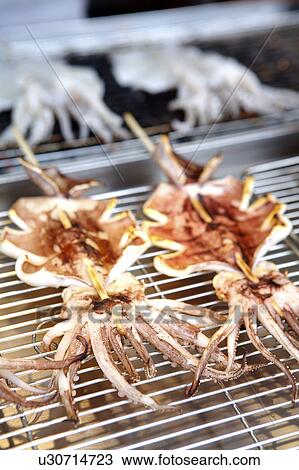 Stock Image - Roasted squid on barbecue, close up. Fotosearch