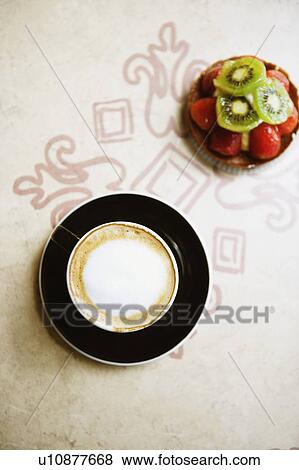 Stock Photo - Close-up of a coffee cup on a saucer with a strawberry tart. Fotosearch