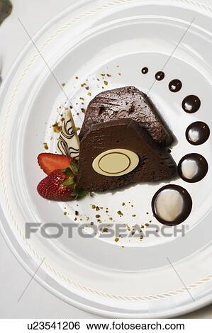 Close-up of two slices of chocolate cake with a strawberry in a plate View Large Photo Image Stock Photograph - Close-up of two slices of chocolate cake with a strawberry in a plate. Fotosearch