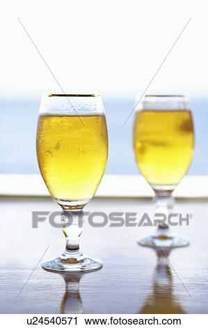 Stock Image - Close-up of two stem glasses of beer. Fotosearch