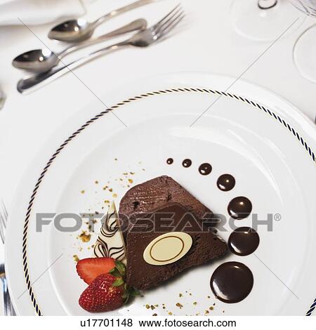 Stock Photo - High angle view of two pieces of a chocolate cake with a strawberry in a plate. Fotosearch