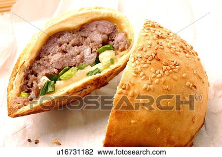 Stock Image - Close-up of a meat stuffed dumpling topped with sesame seeds. Fotosearch