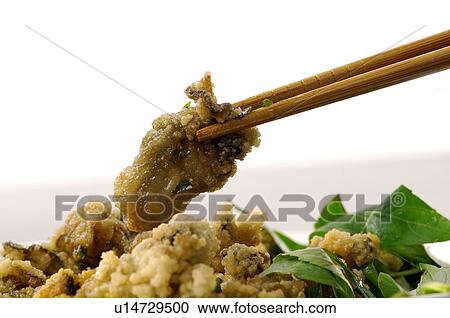 Stock Image - Close-up of Oriental batter fried meat with greens. Fotosearch
