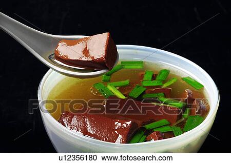 Stock Image - Close-up of Oriental kidney pig blood soup garnished with leeks. Fotosearch