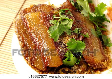 Stock Photo - Close-up of roast sliced pork garnished with coriander. Fotosearch