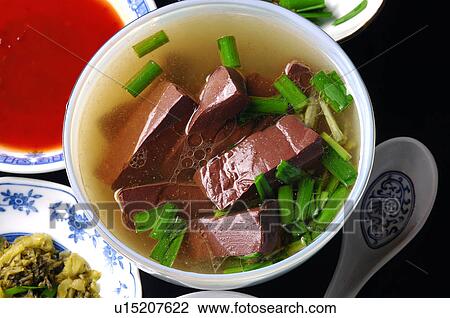 Stock Image - High angle view of Oriental pig blood soup garnished with leeks. Fotosearch