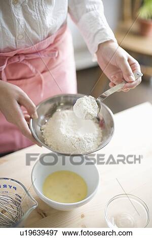 Stock Photo - Human hand of young woman cooking bread. Fotosearch