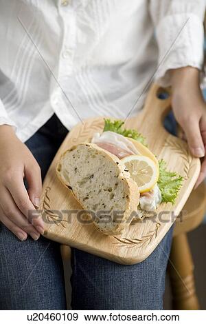 Human hand of young woman holding sandwiches on board View Large Photo Image Stock Photo - Human hand of young woman holding sandwiches on board. Fotosearch