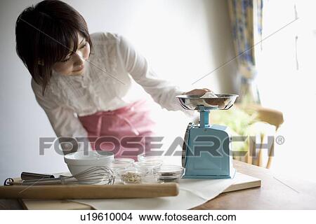 Young woman measuring ingredient View Large Photo Image Picture - Young woman measuring ingredient. Fotosearch