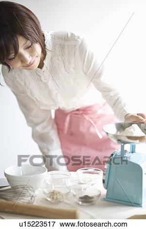 Young woman measuring ingredient View Large Photo Image Stock Photo - Young woman measuring ingredient. Fotosearch