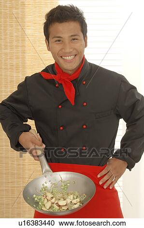 Stock Image - Asian cook with a peking pan. Fotosearch