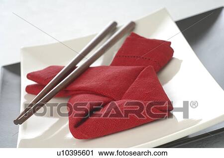 Stock Image - Asian place setting with a red napkin and chopsticks. Fotosearch