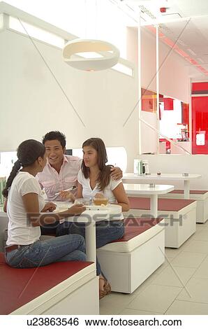 Stock Photograph - Group of young people in a sushi bar. Fotosearch