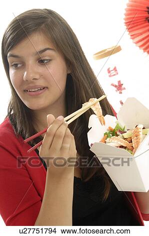 Woman is eating shrimps in a lunch box with chopsticks View Large Photo Image Picture - Woman is eating shrimps in a lunch box with chopsticks. Fotosearch