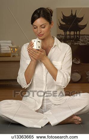 Woman sitting cross-legged with a cup of tea View Large Photo Image Stock Photography - Woman sitting cross-legged with a cup of tea. Fotosearch