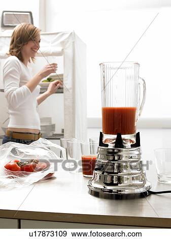Blender with tomato juice and a woman in the background View Large Photo Image Stock Photo - Blender with tomato juice and a woman in the background. Fotosearch