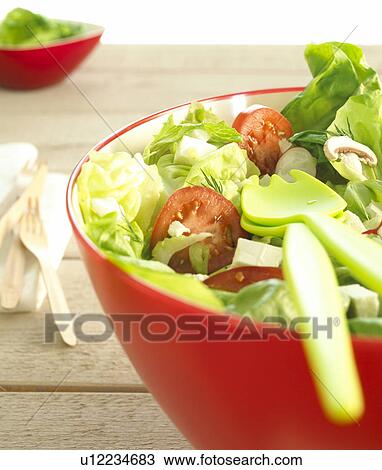Stock Image - Mixed salad in a red bowl. Fotosearch