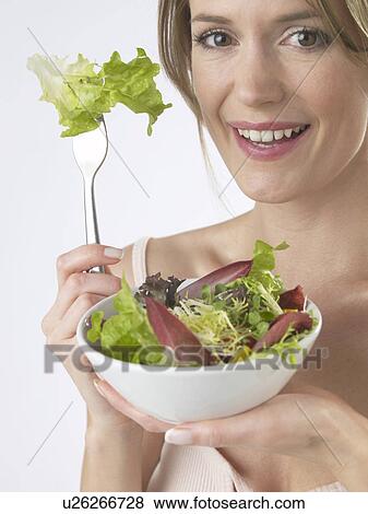 Stock Photo - Woman is eating salad. Fotosearch