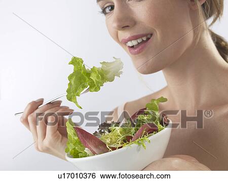 Stock Photograph - Woman is eating salad. Fotosearch