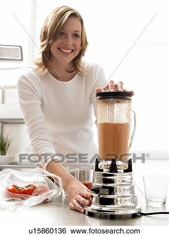Woman is mixing tomato juice with a blender View Large Photo Image Stock Photograph - Woman is mixing tomato juice with a blender. Fotosearch