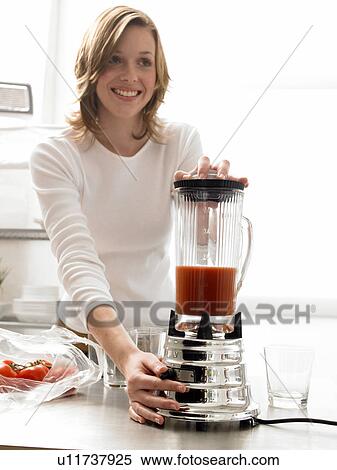 Woman is mixing tomato juice with a blender View Large Photo Image Stock Photography - Woman is mixing tomato juice with a blender. Fotosearch