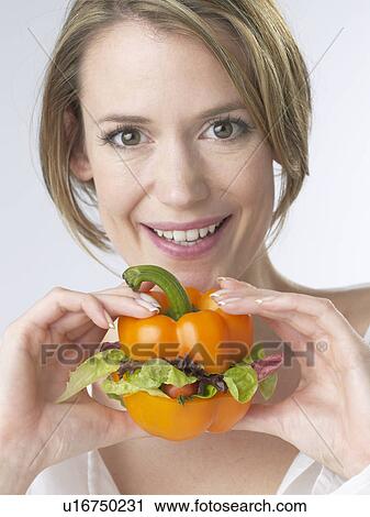 Stock Image - Woman with a paprika pepper burger. Fotosearch
