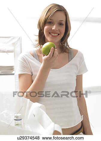 Woman with an apple View Large Photo Image Stock Photo - Woman with an apple. Fotosearch
