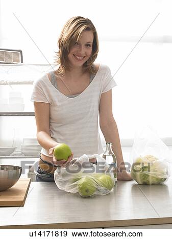 Woman with apples in the kitchen View Large Photo Image Stock Photo - Woman with apples in the kitchen. Fotosearch
