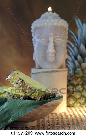 Stock Photo - Pineapple and a Buddha candle. Fotosearch