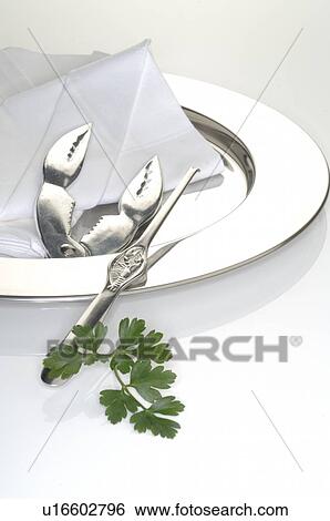 Stock Photograph - Lobster cracker and fork on a silver plate. Fotosearch