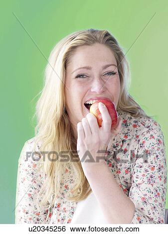 Stock Photograph - Blonde woman with an apple. Fotosearch